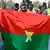Des partisans de l'AES brandissent un drapeau du Burkina Faso fait maison (archive de janvier 2024)