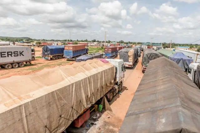 Longue file de camions bloqués à la frontière bénino-nigérienne à Malanville, illustrant les conséquences économiques de la crise