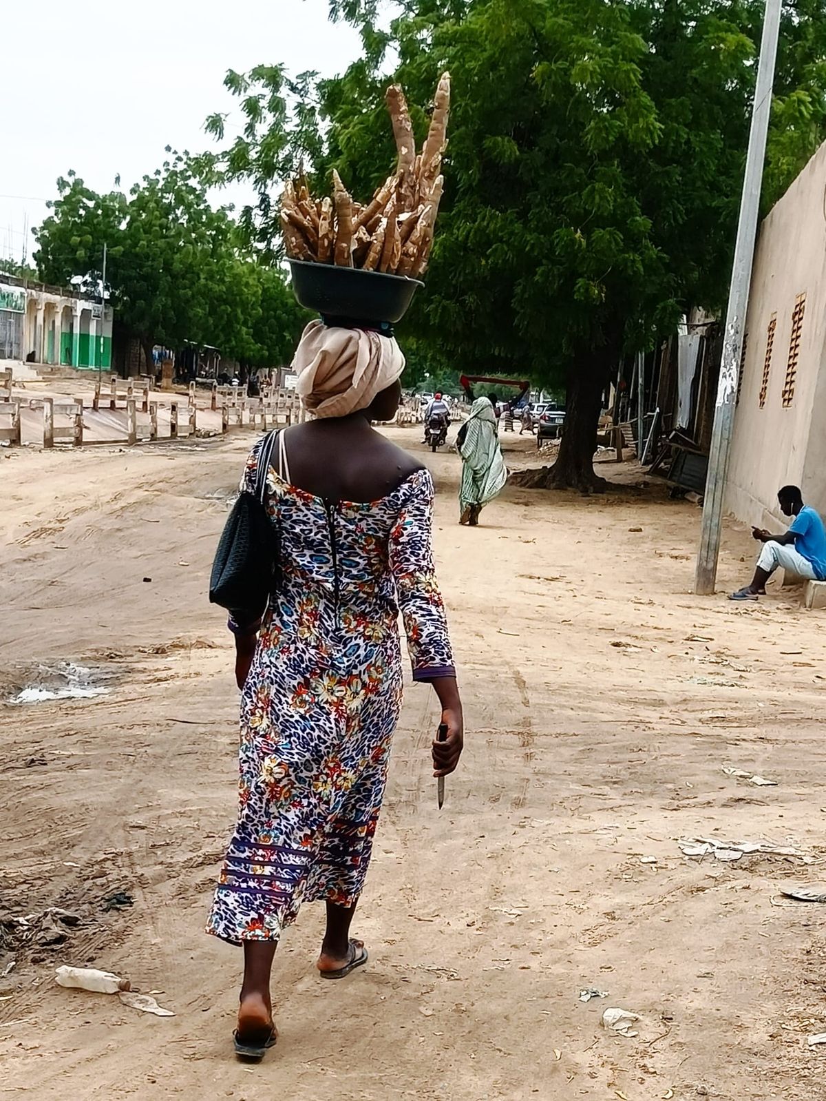 Une jeune lycéenne tchadienne transporte une bassine de manioc dans les rues de N’Djamena